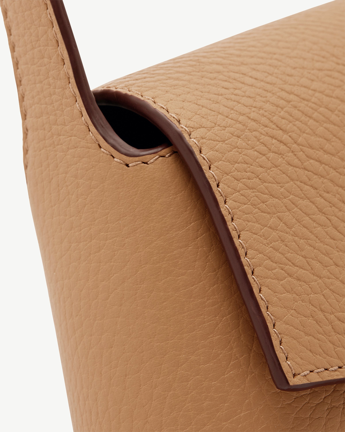 Caramel pebbled leather shoulder bag showing strap edge and stitching