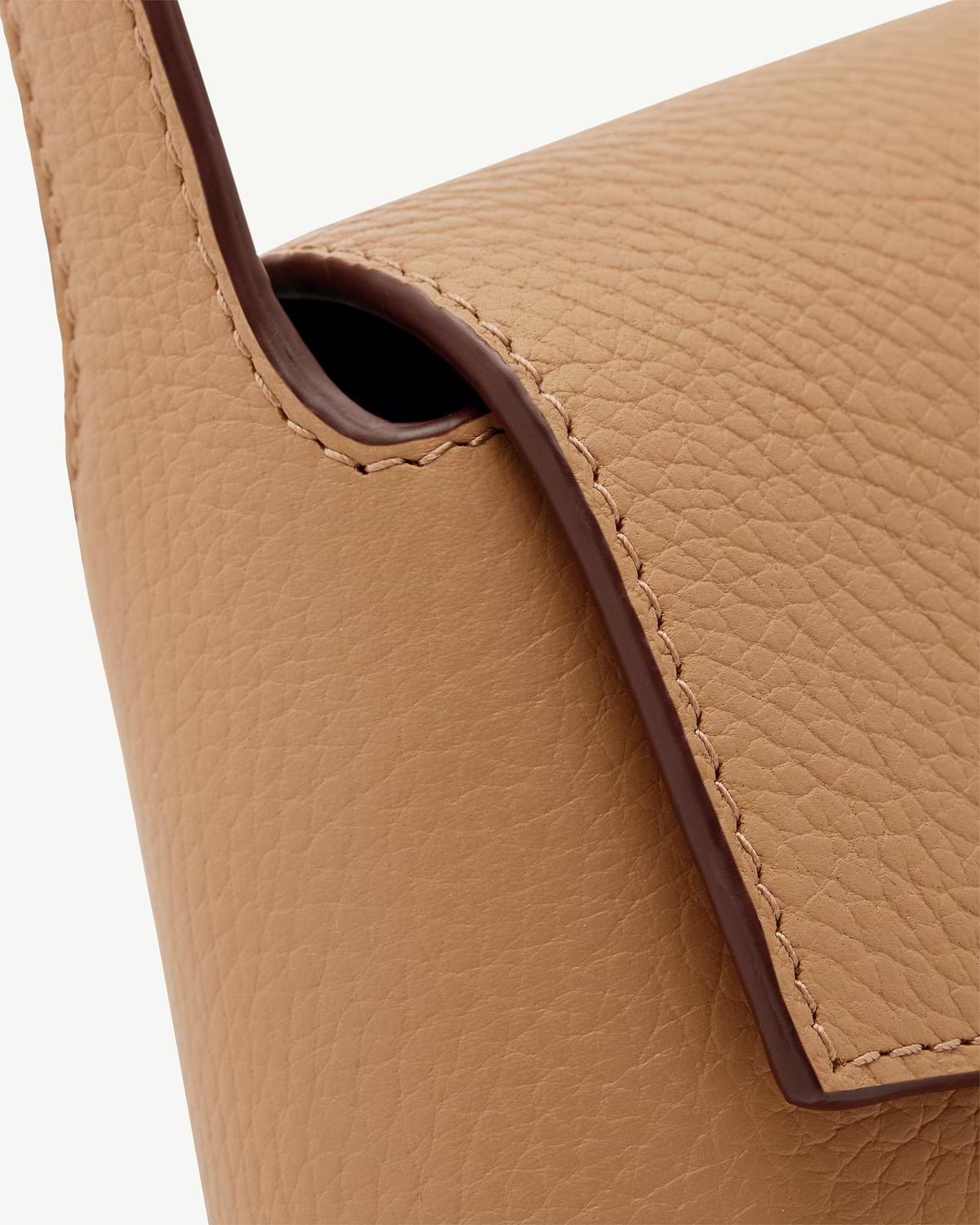 Caramel pebbled leather shoulder bag showing strap edge and stitching