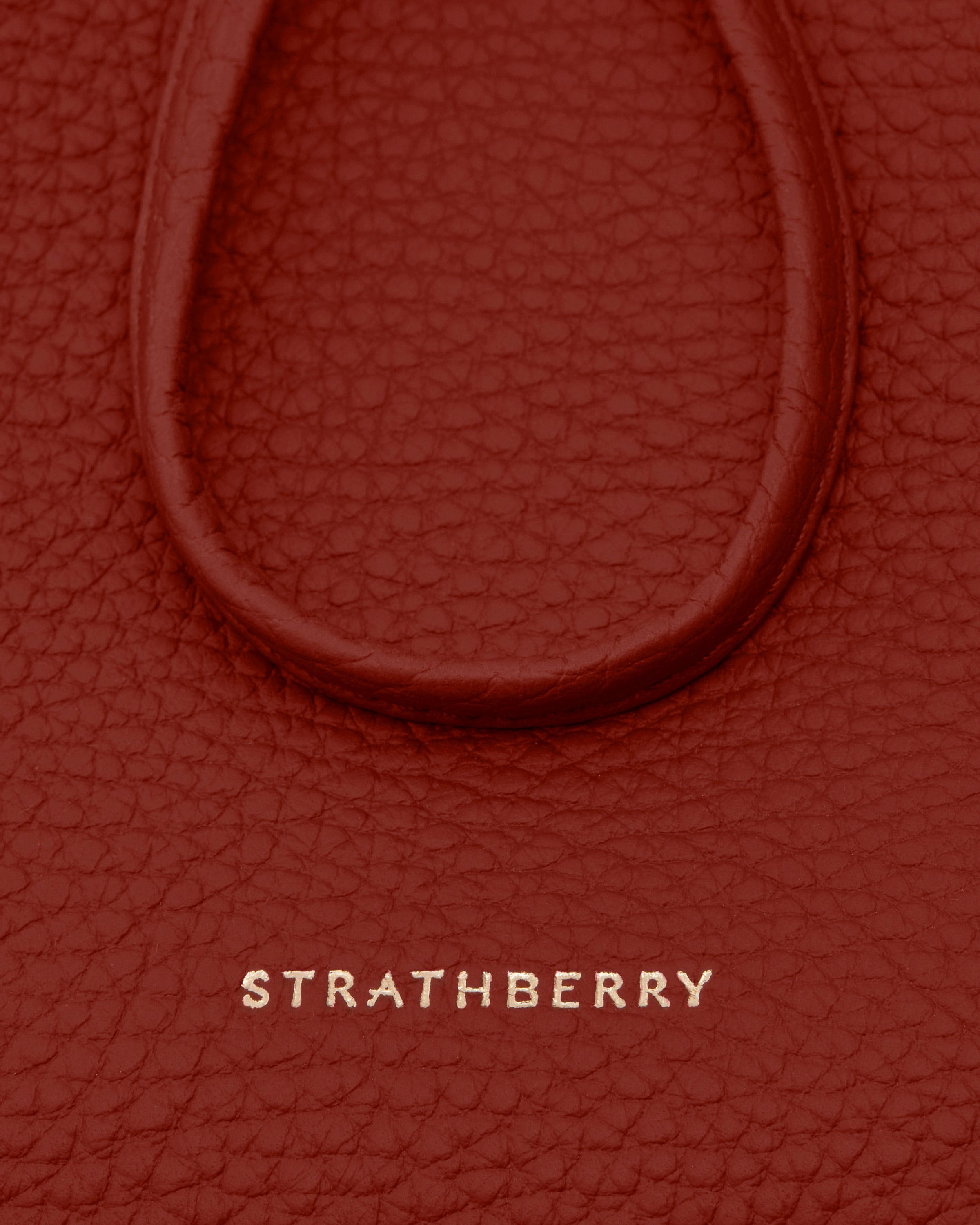 Levanto red textured leather with embossed Strathberry logo and rounded trim