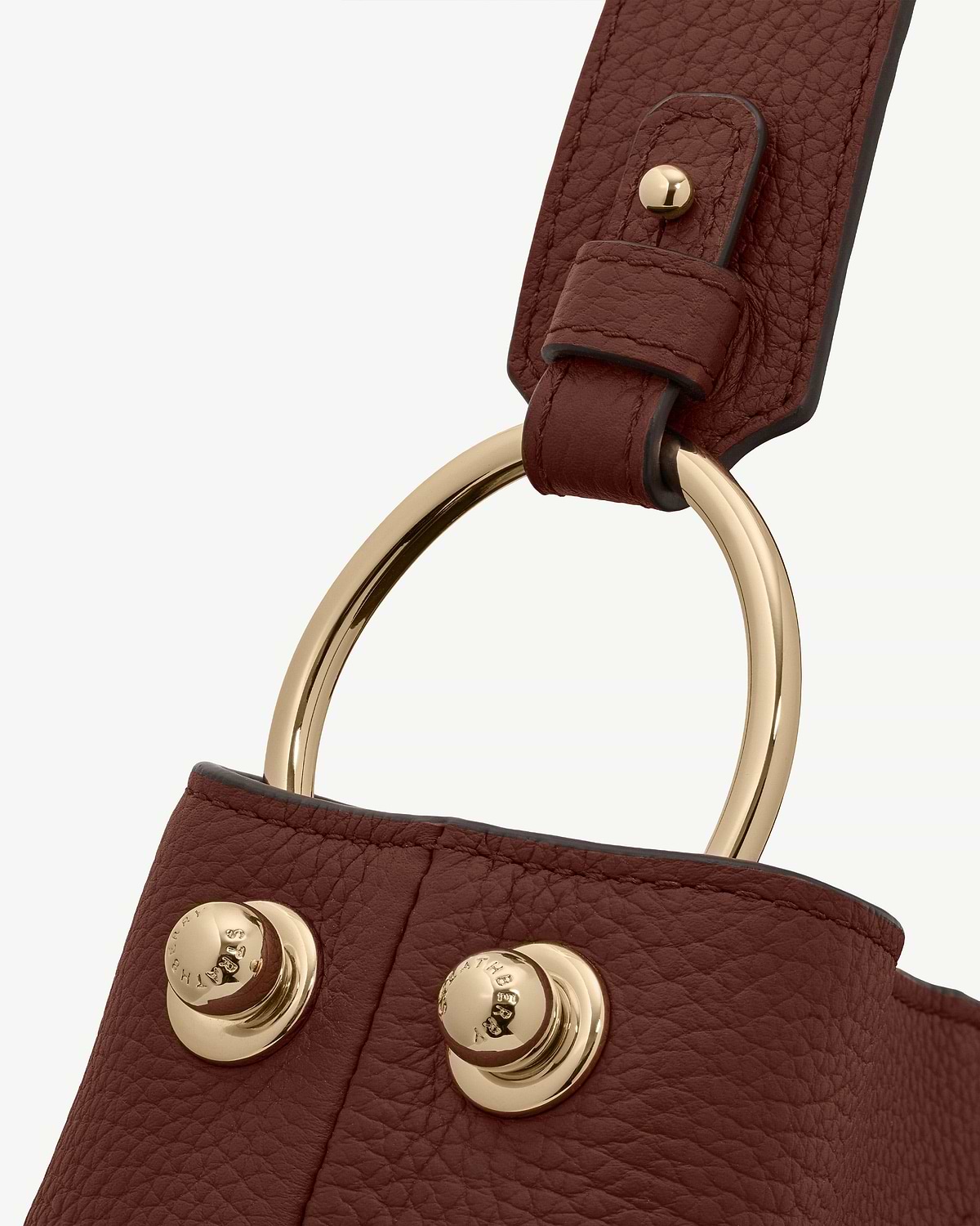 Close-up of Strathberry Lana Hobo walnut pebbled leather strap with gold ring and studs.
