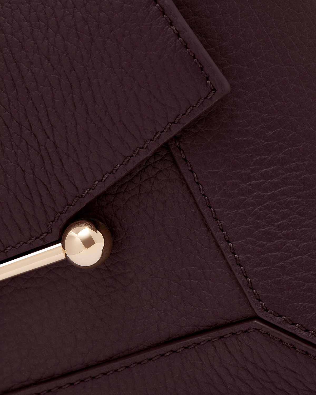 Burgundy grained leather mosaic panels with visible stitching and gold ball hardware.