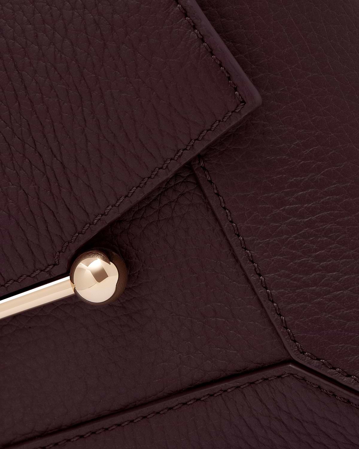 Burgundy grained leather mosaic panels with visible stitching and gold ball hardware.