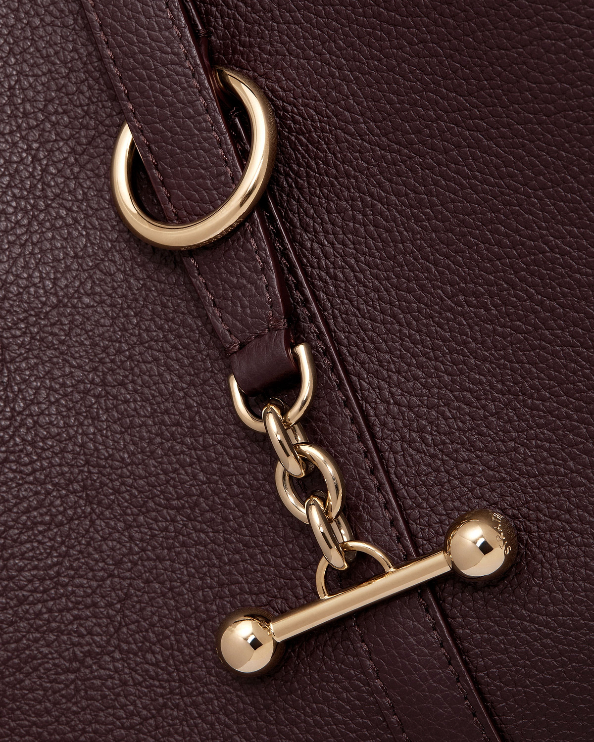 Burgundy pebbled leather with gold chain links and toggle fastener.