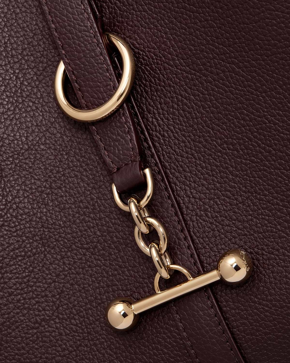 Burgundy pebbled leather with gold chain links and toggle fastener.