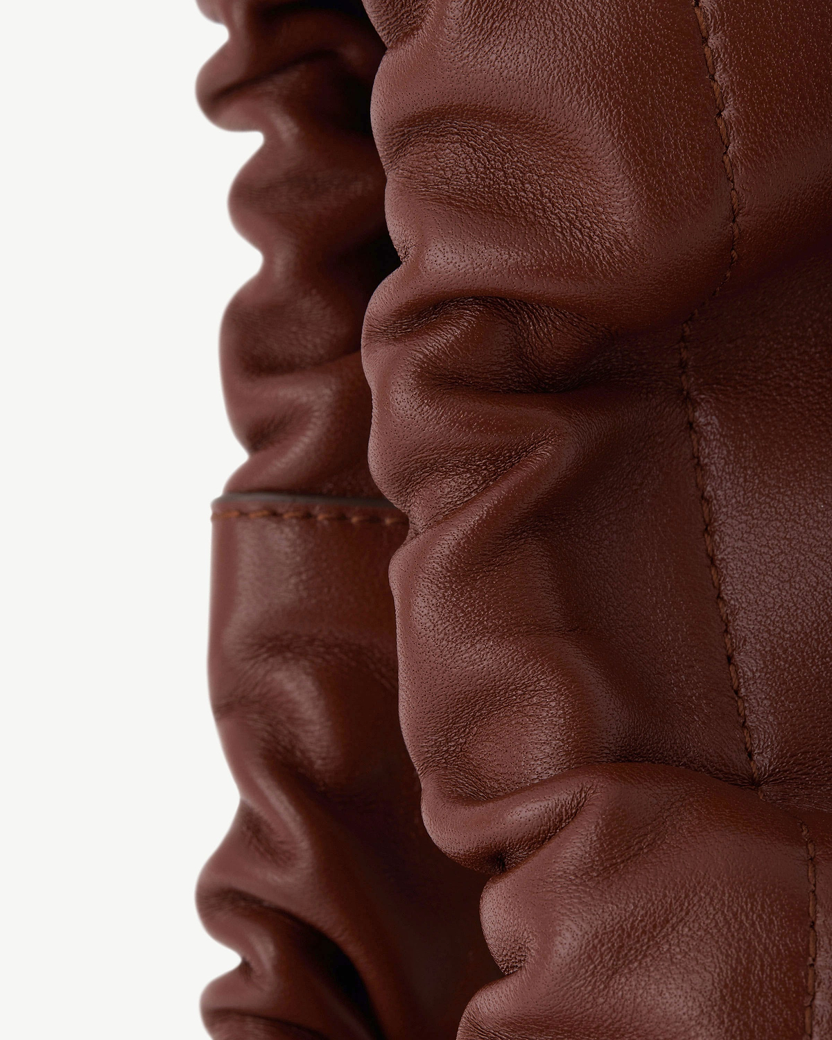 Close-up of walnut leather ruched drawstring detail with visible stitching.
