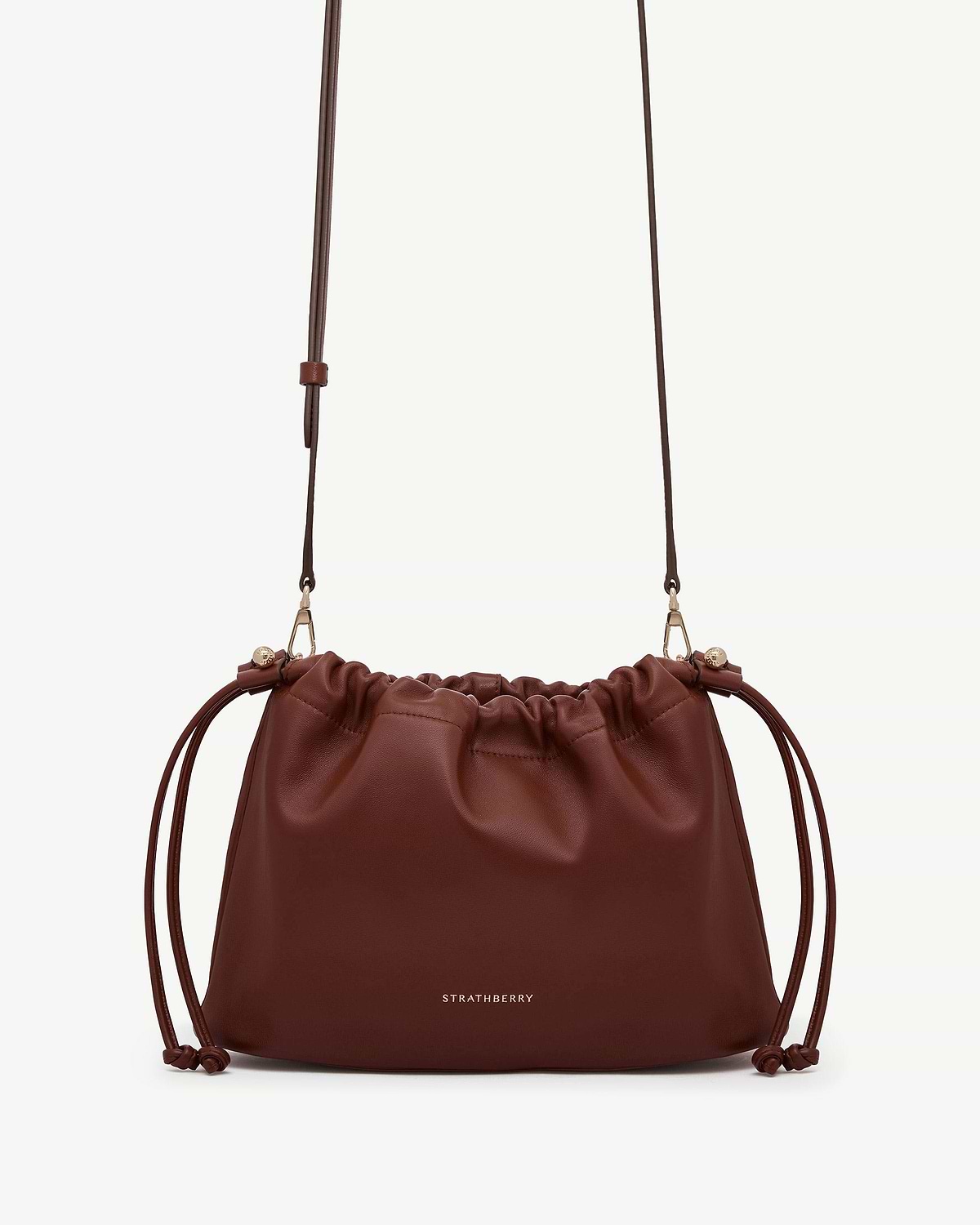 Strathberry Charlotte Midi drawstring bag in walnut leather with gold logo.