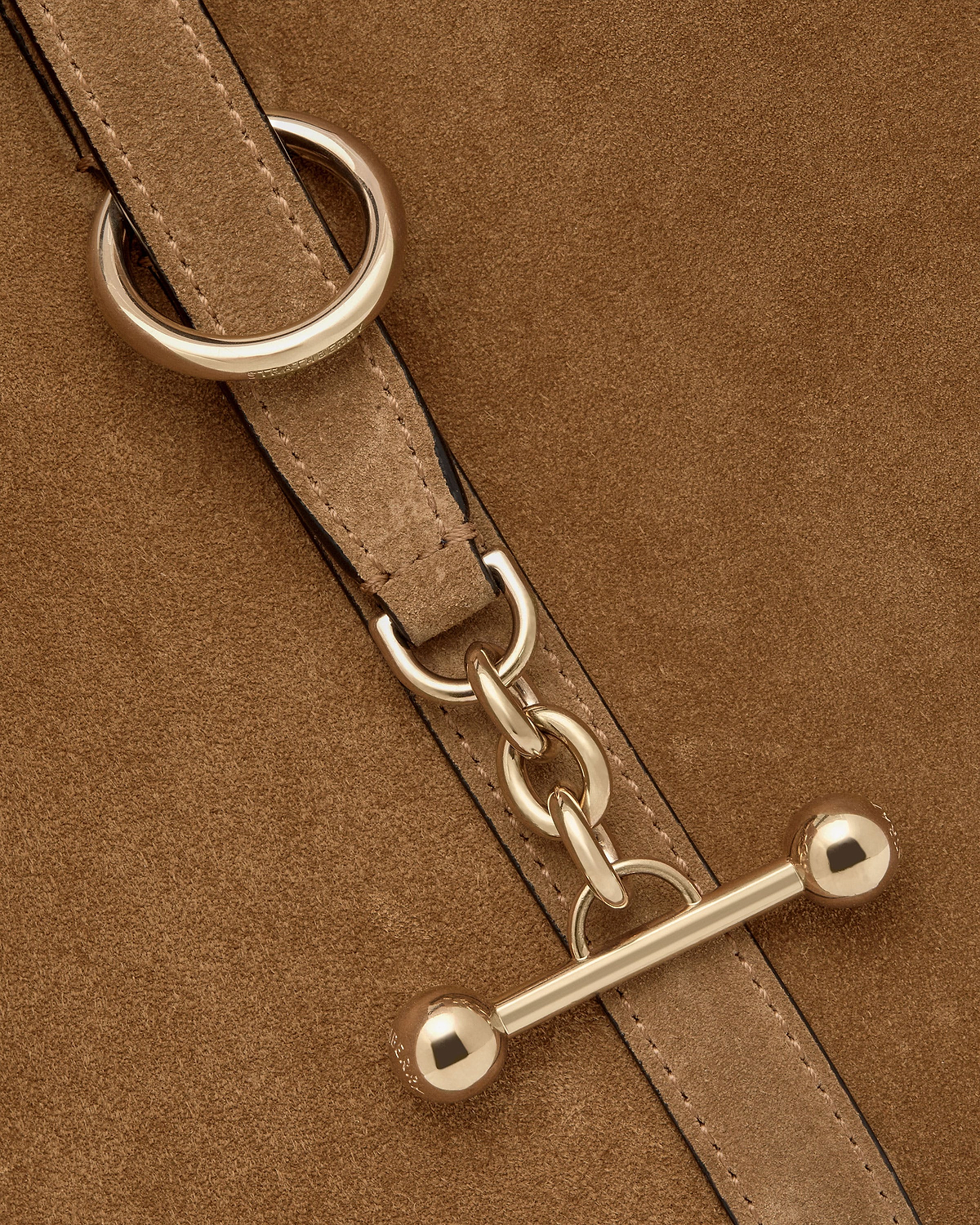 Toffee suede strap with gold chain and bar toggle hardware, Strathberry engraving visible.