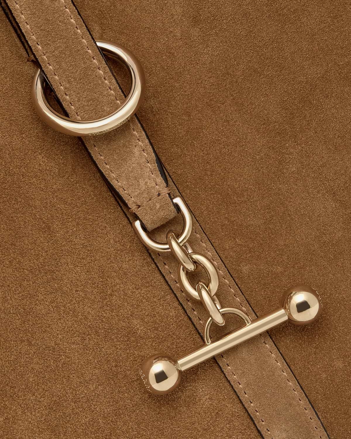 Toffee suede strap with gold chain and bar toggle hardware, Strathberry engraving visible.