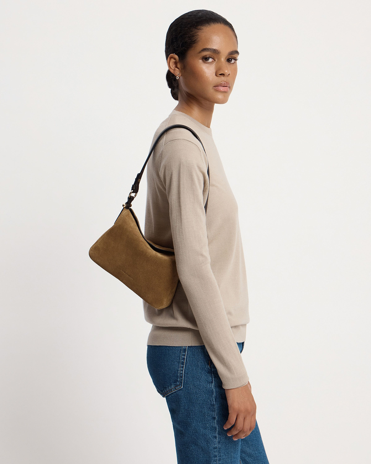 Model wearing beige top and jeans carrying toffee suede shoulder bag with espresso-coloured strap.