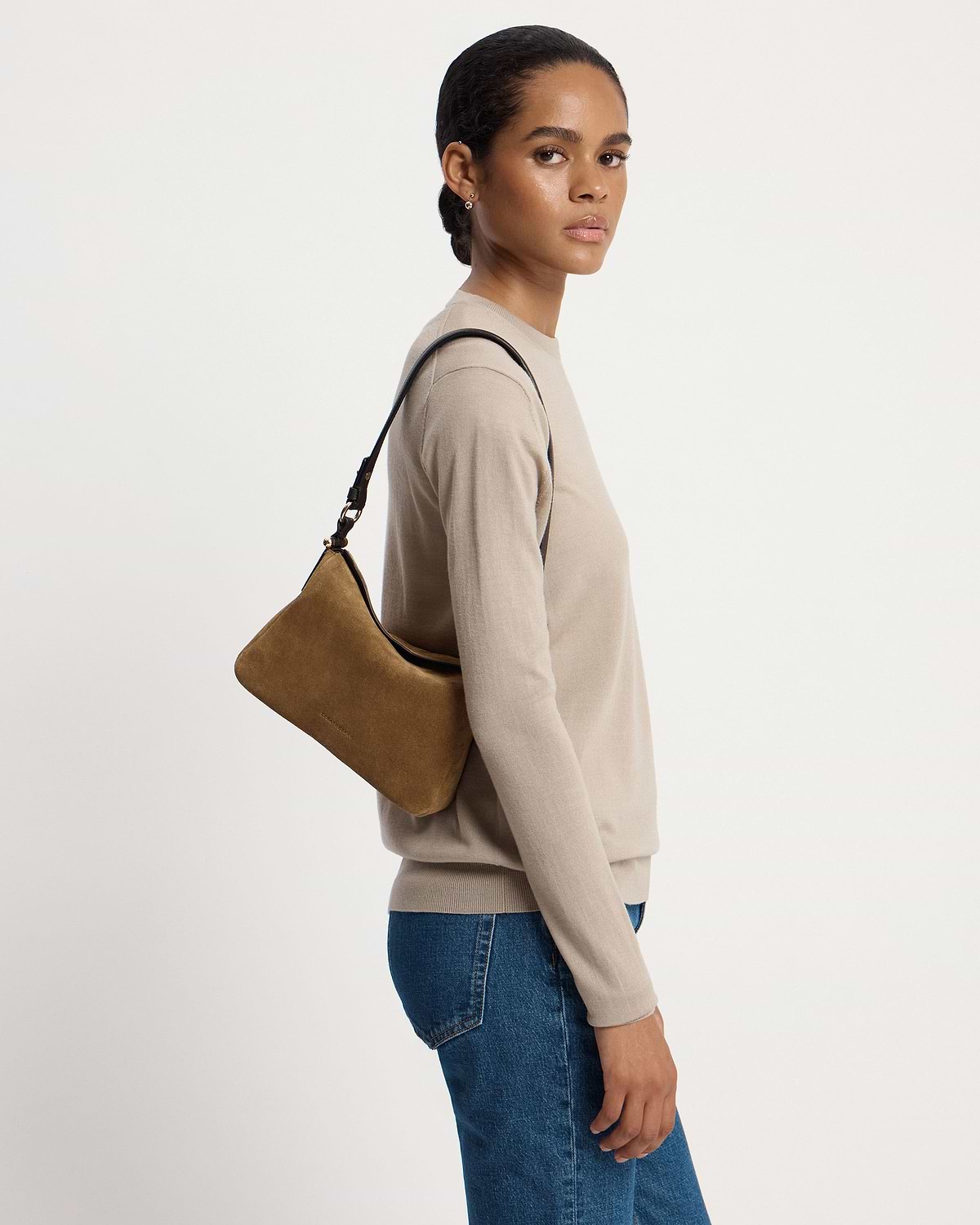 Model wearing beige top and jeans carrying toffee suede shoulder bag with espresso-coloured strap.