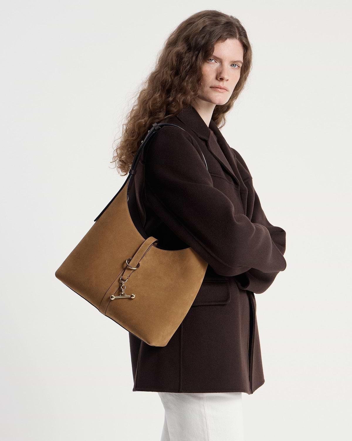 Model wearing a toffee suede and espresso kite hobo shoulder bag