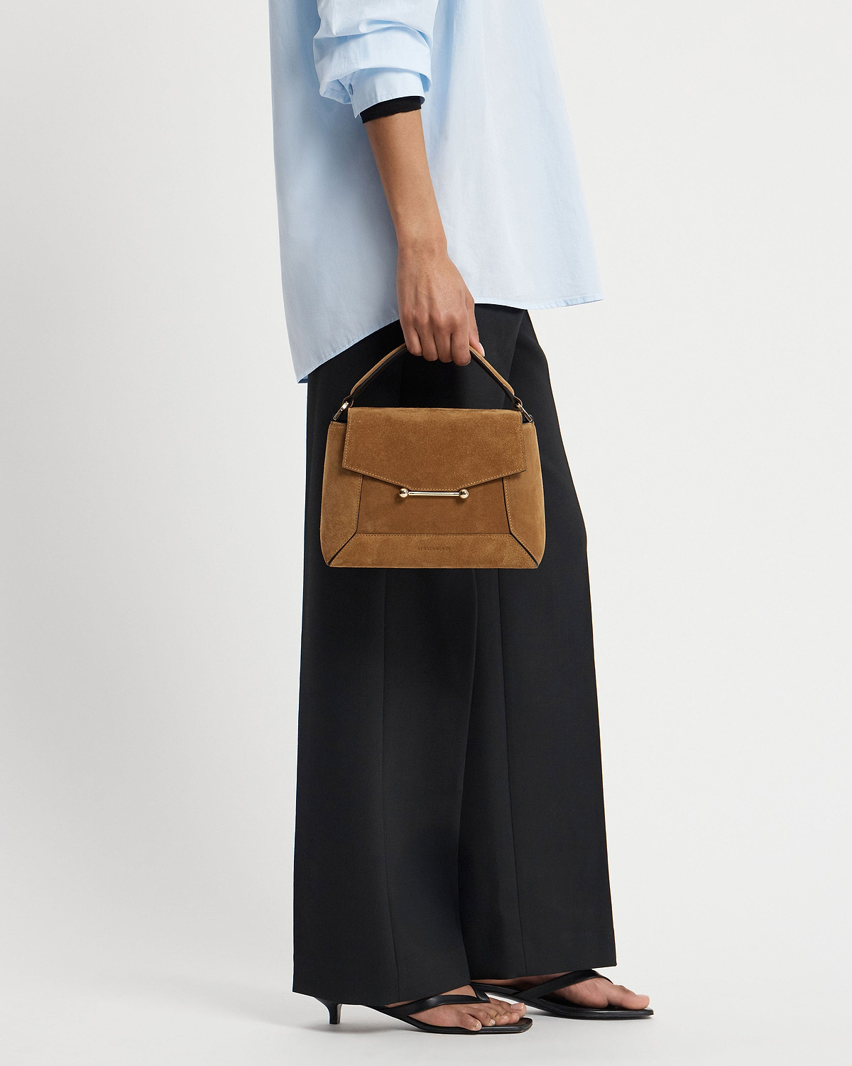 Model holding toffee suede mosaic bag with espresso trim and top handle.