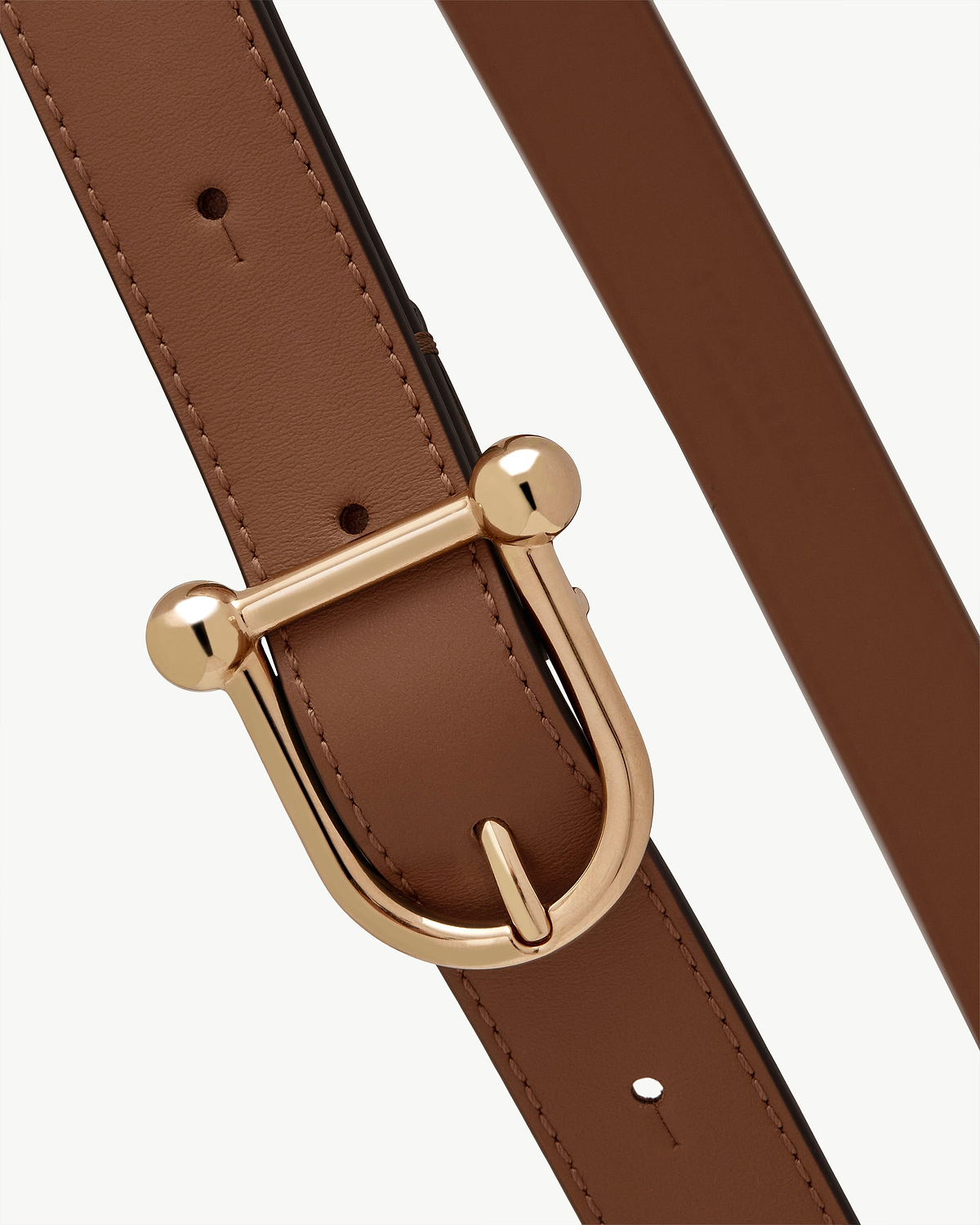 Close-up detail of hazelnut leather belt strap and gold-tone buckle