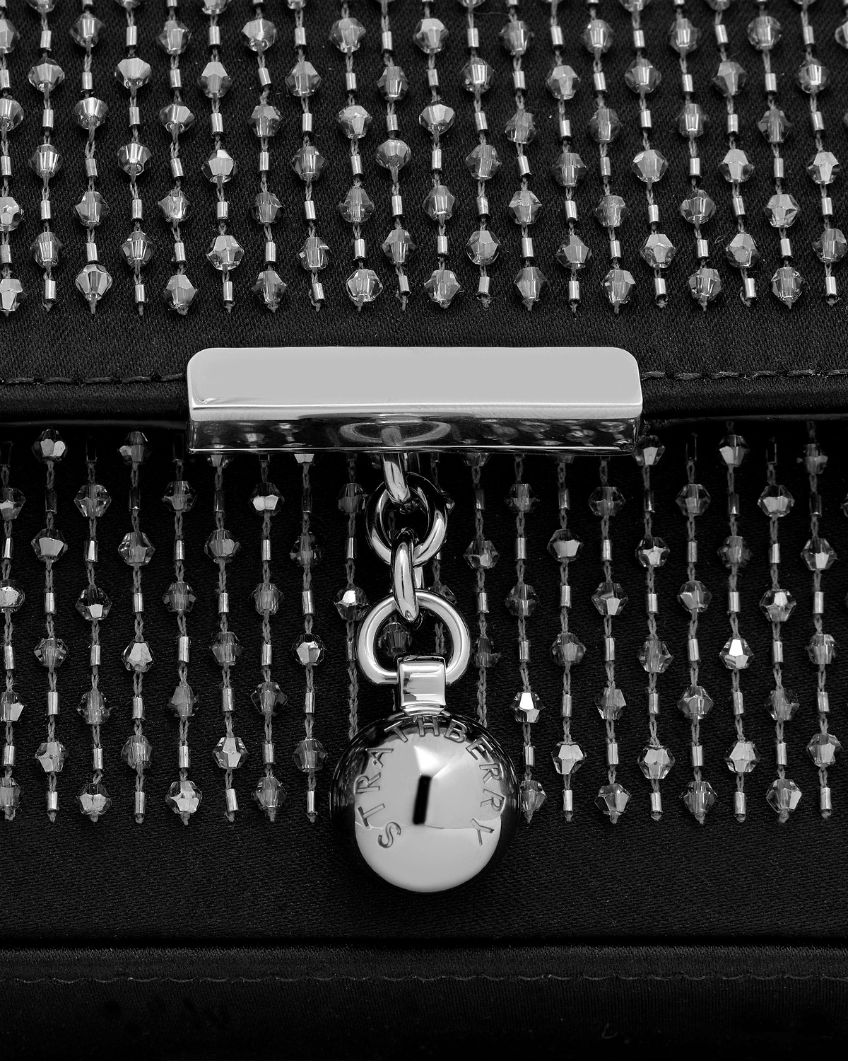 Black embroidered satin clutch with vertical crystal beading, silver clasp and Strathberry charm.