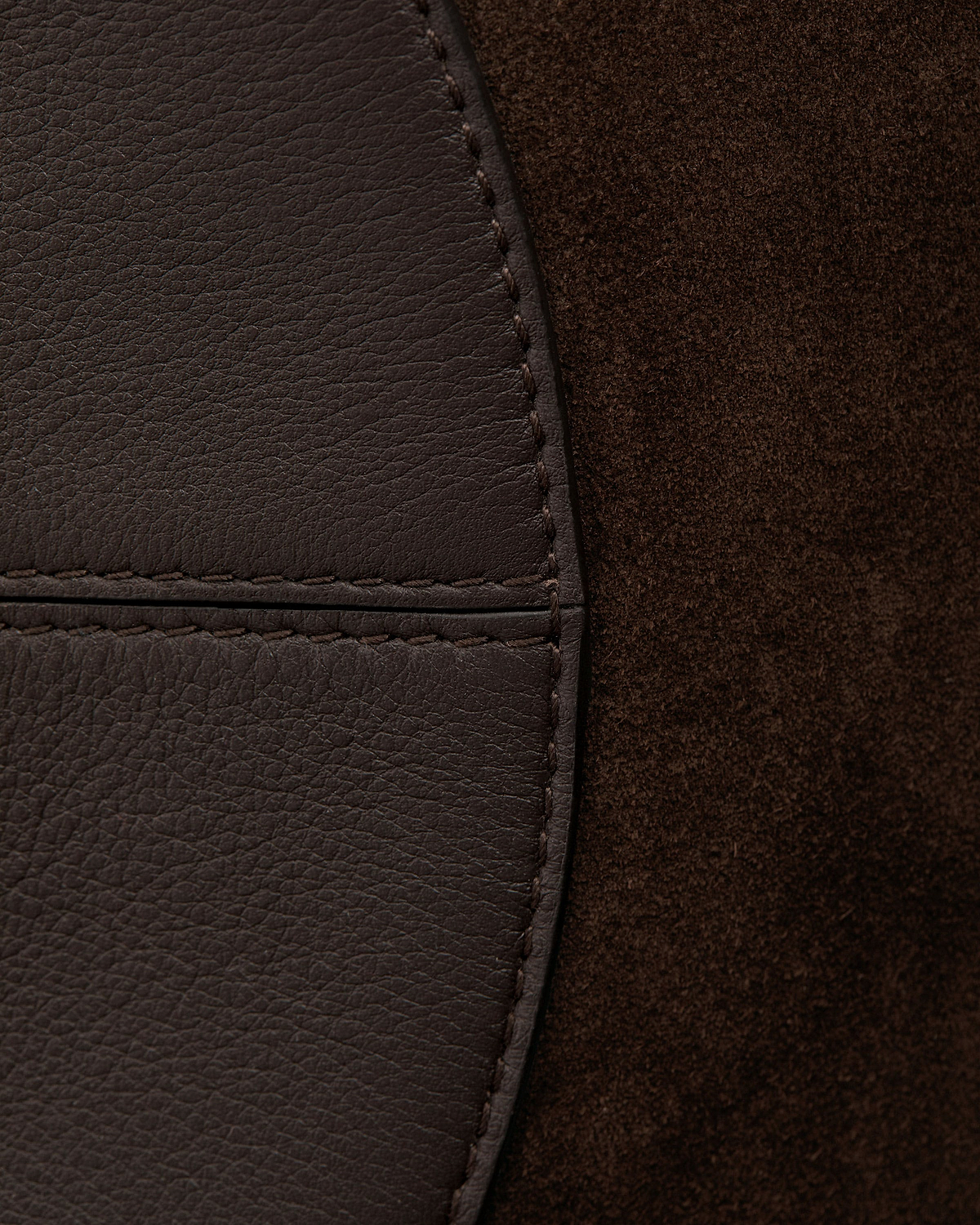 Espresso suede and pebbled leather panel of bag with visible stitching
