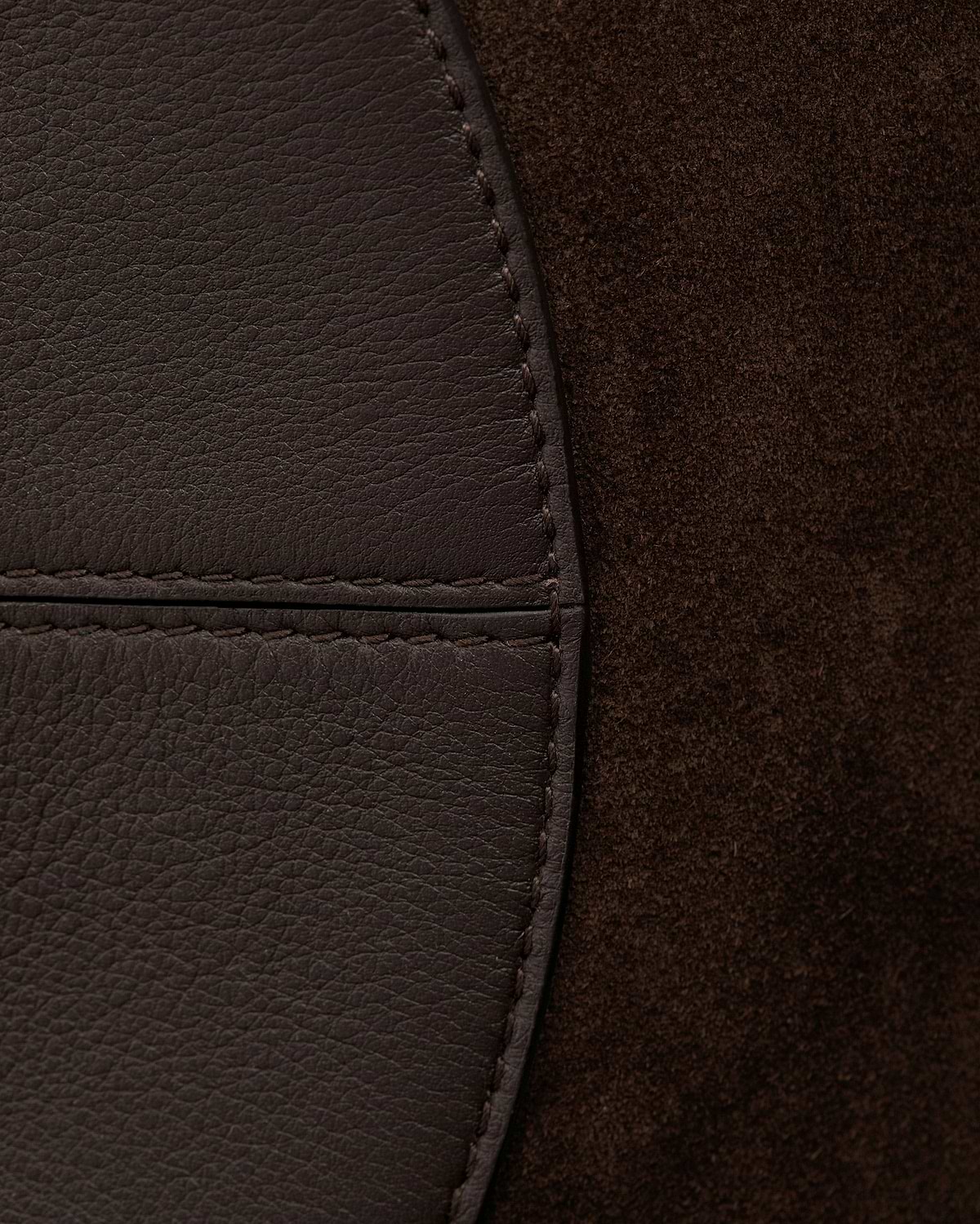Espresso suede and pebbled leather panel of bag with visible stitching