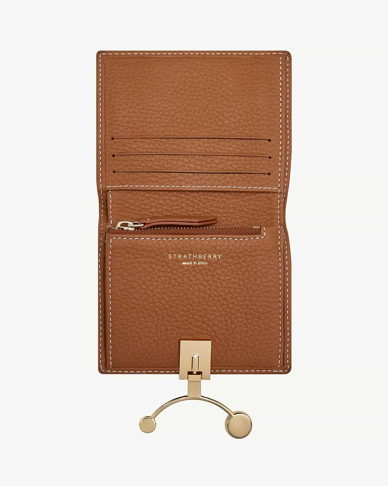 Tan leather crescent wallet open with card slots, zip pocket, vanilla stitching and Strathberry logo.