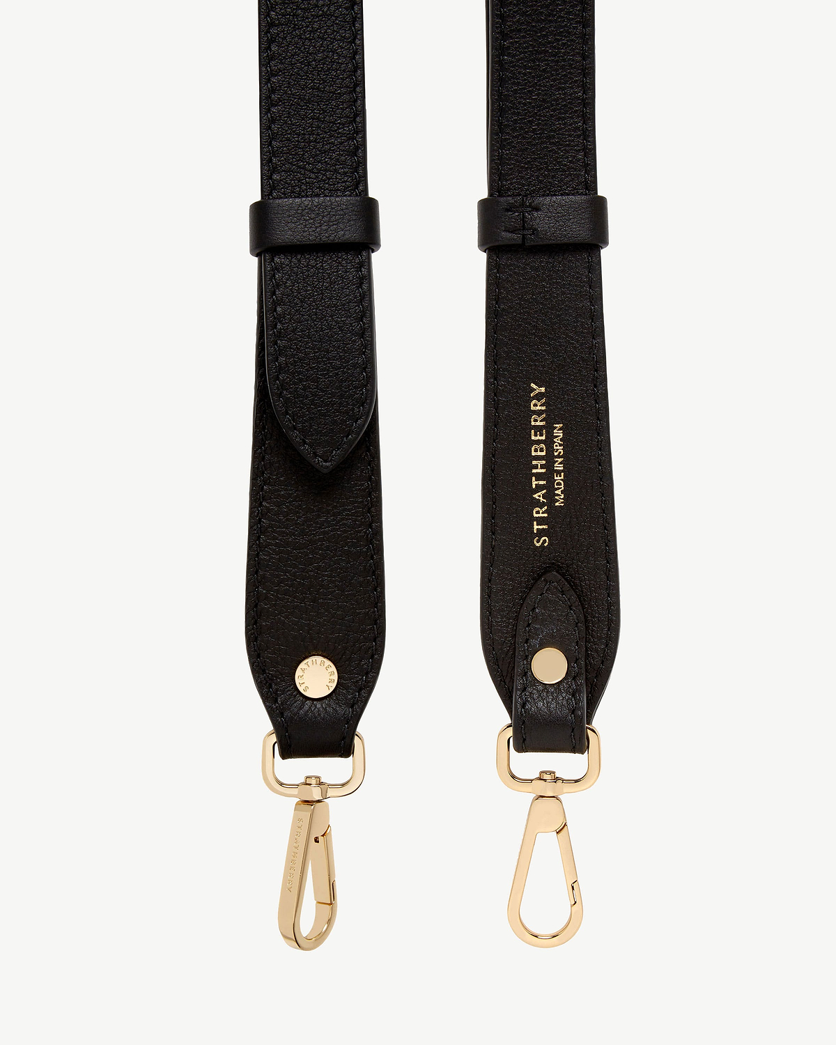 Black adjustable leather strap with gold hardware and Strathberry stamped logo.