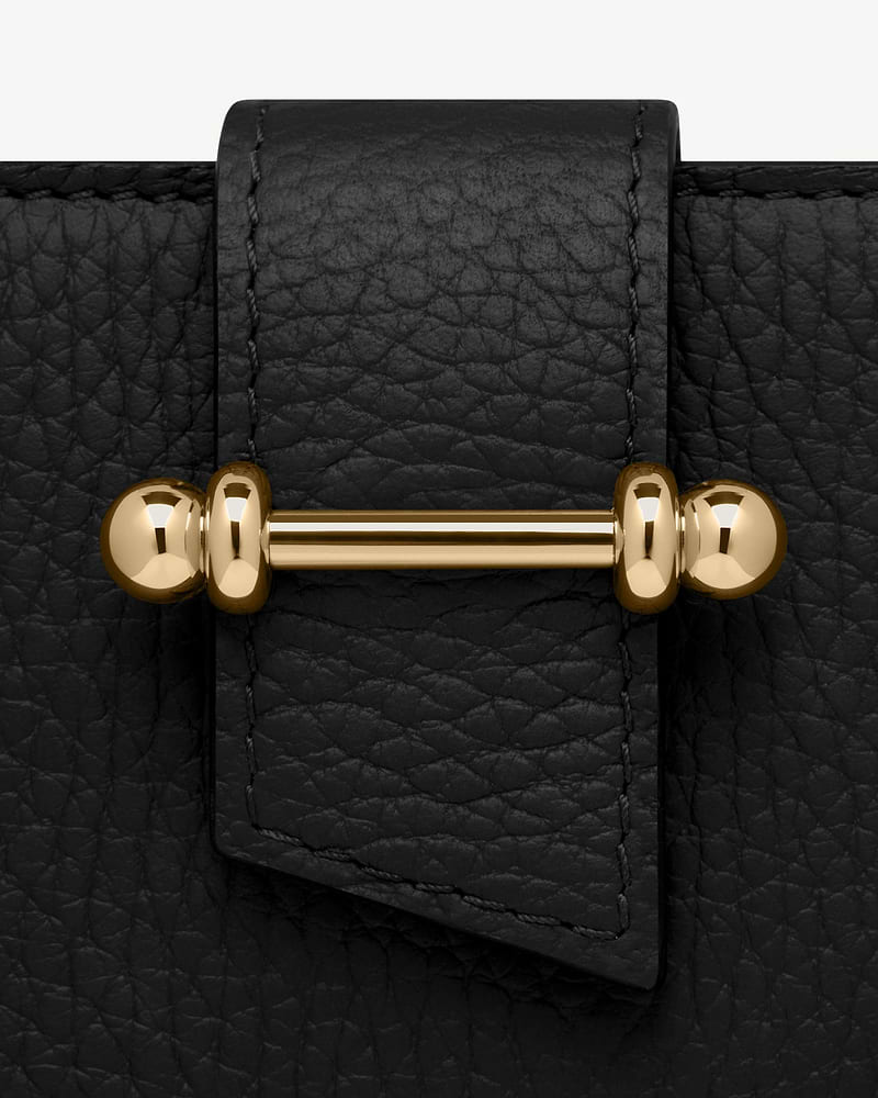 Black grained leather strap with visible stitching and gold bar hardware detail.