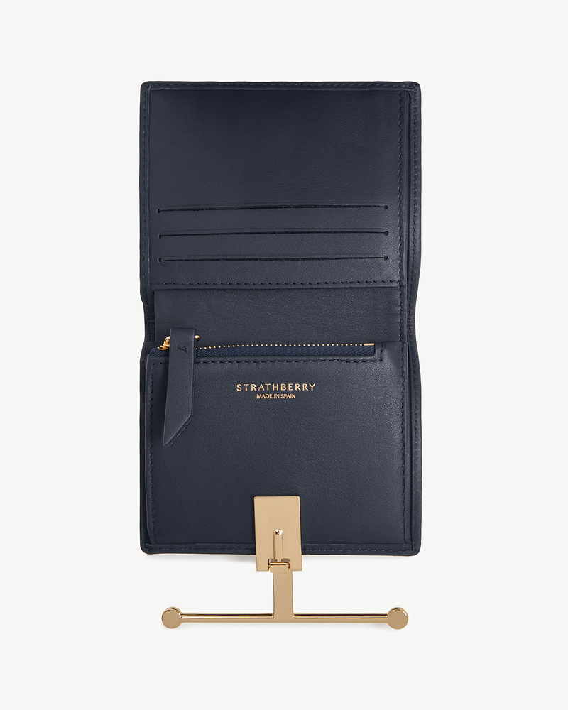 Open marine blue Strathberry Melville Street wallet showing card slots and gold bar closure.