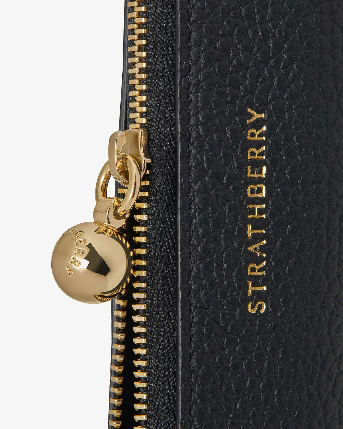 Black pebble leather pencil case with gold zip pull and Strathberry logo.