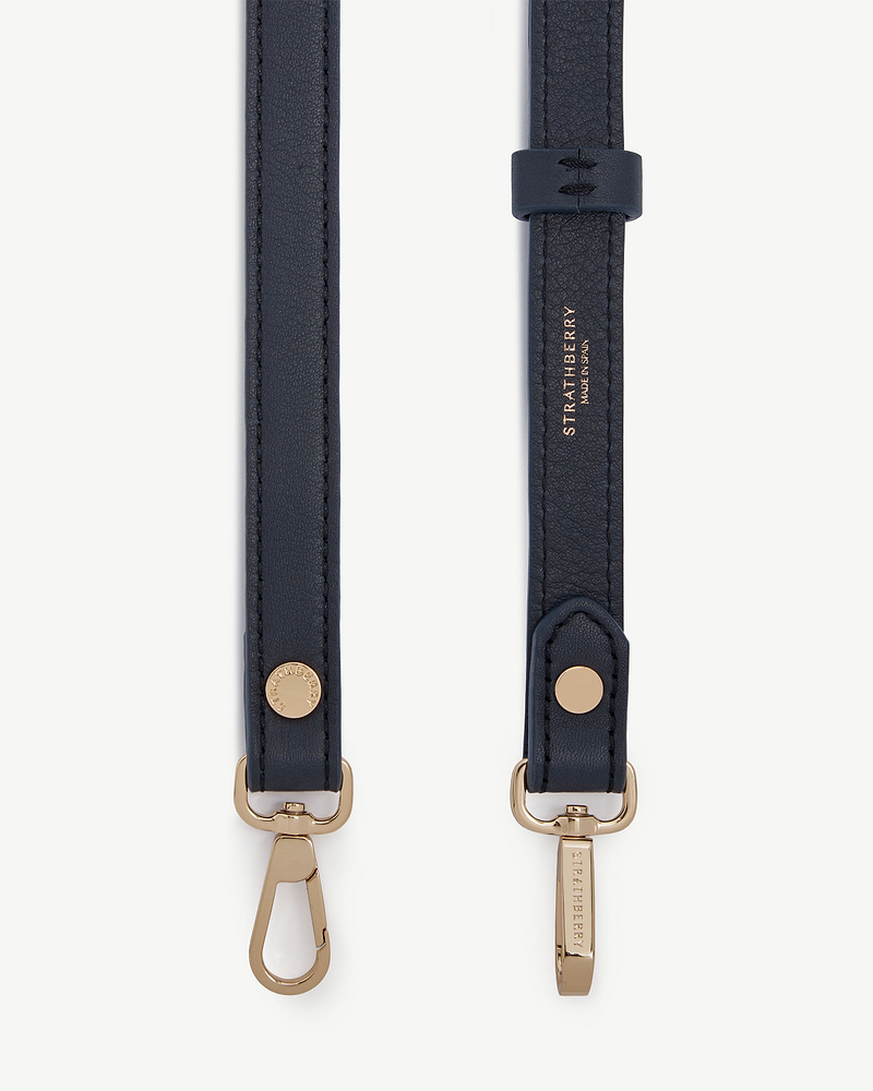Marine blue thin adjustable leather strap with gold hardware and Strathberry logo.