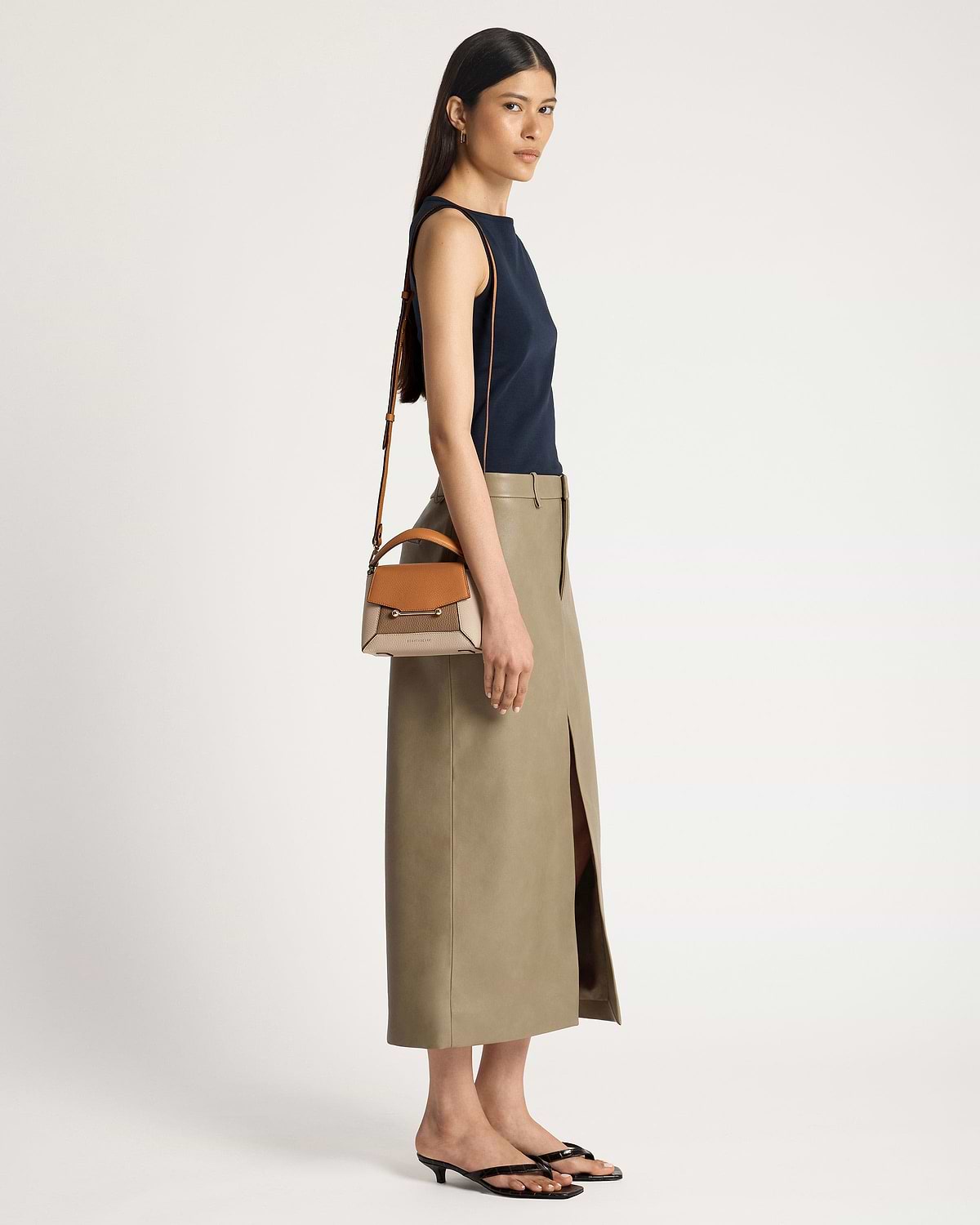 Model carrying a Mosaic Nano bag in oat, honey and clay tones.