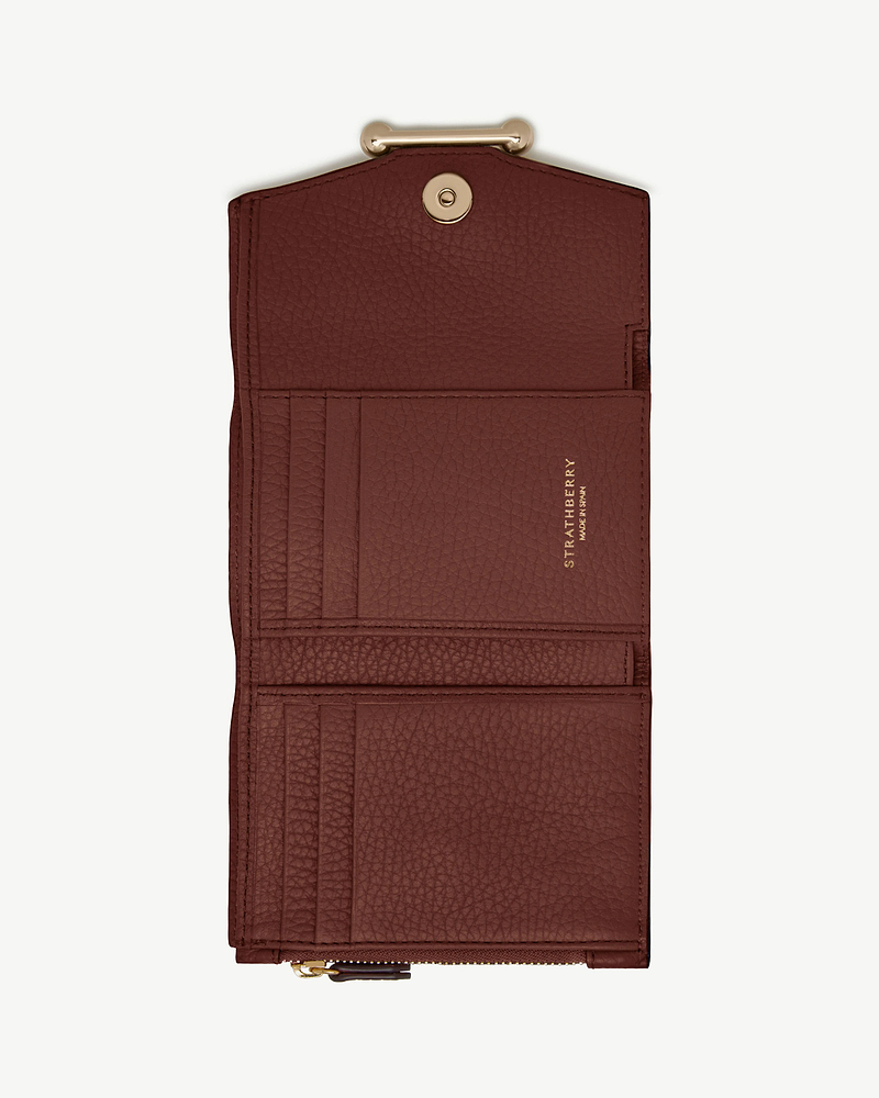 Strathberry mosaic trifold wallet in walnut leather, open with card slots and snap closure.