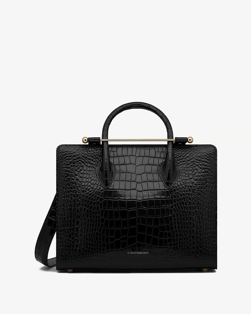Strathberry midi tote in black croc-embossed leather with top handles, shoulder strap and gold bar
