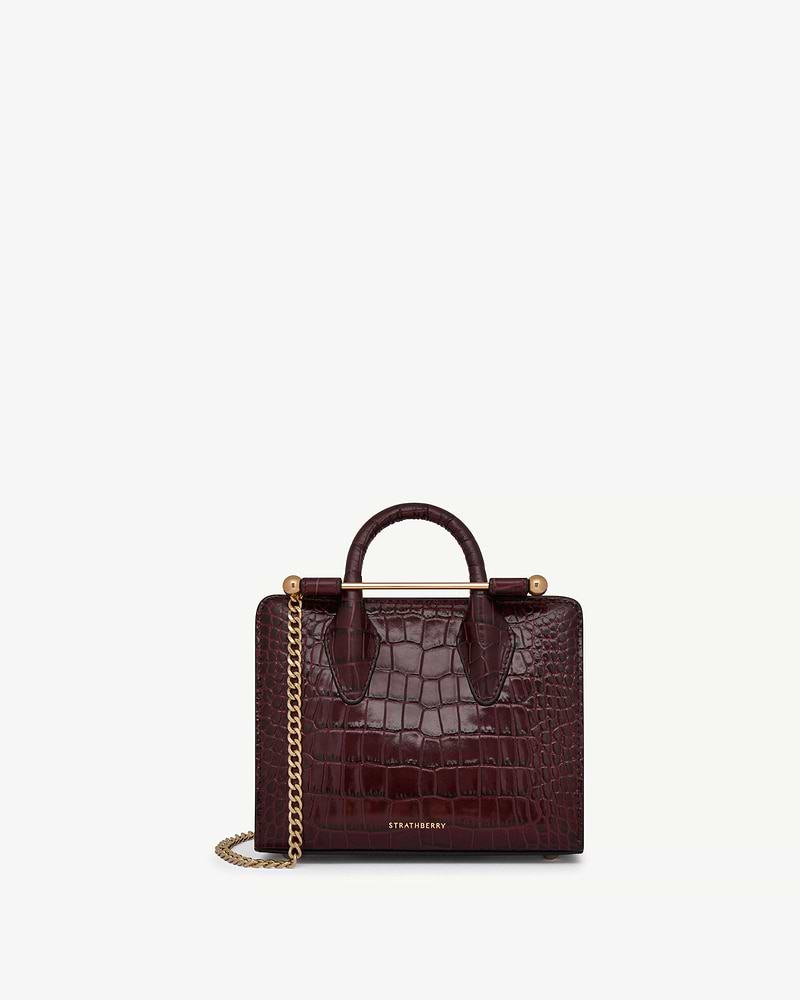 Burgundy croc leather Strathberry nano tote with top handles and gold chain strap.