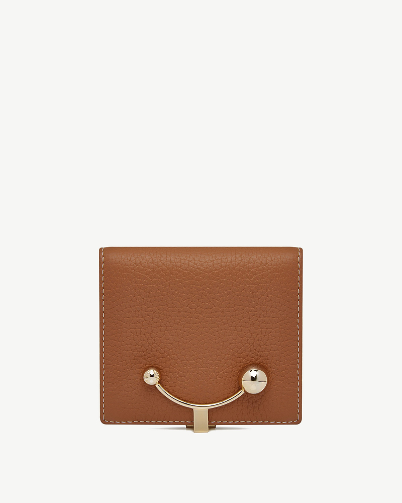 Tan leather crescent wallet with vanilla-coloured stitching and crescent-shaped gold bar closure.