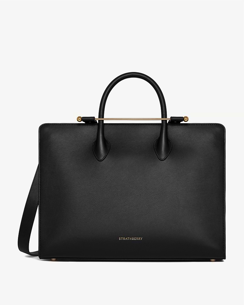 Black leather Strathberry structured tote with rounded handles and gold bar detail.