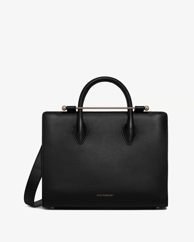 Black Strathberry midi tote with rounded top handles, gold bar and shoulder strap