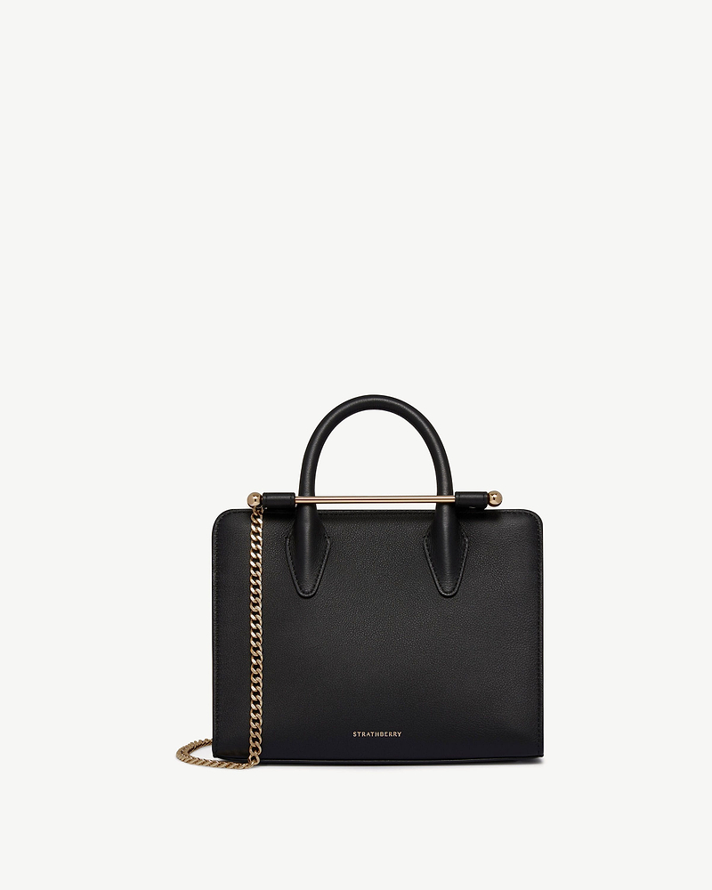 Black Strathberry mini tote with top handles, gold bar closure and chain strap.