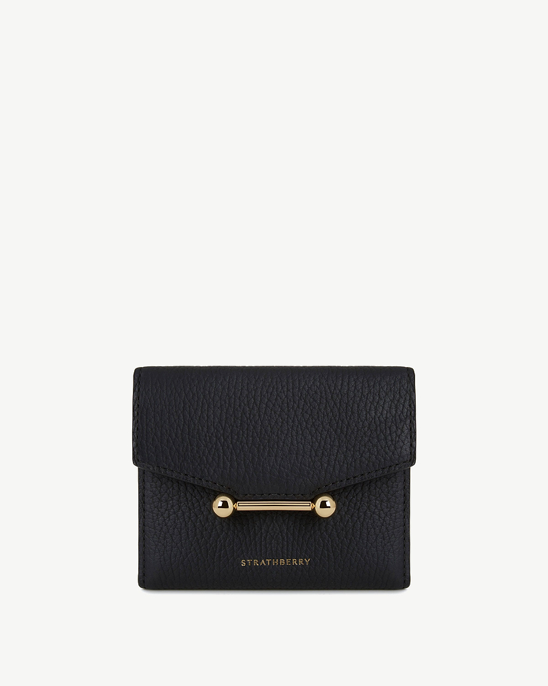 Black textured trifold wallet with gold bar fastening and Strathberry logo.
