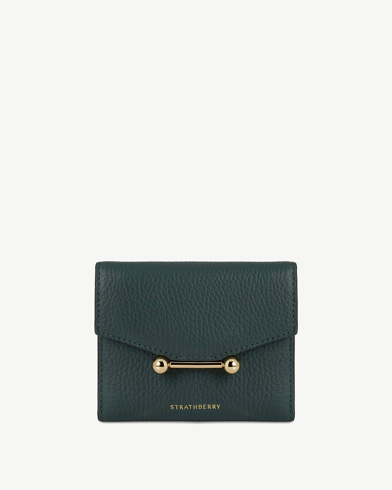 Bottle green trifold wallet in pebbled leather with gold bar detail, Strathberry logo.