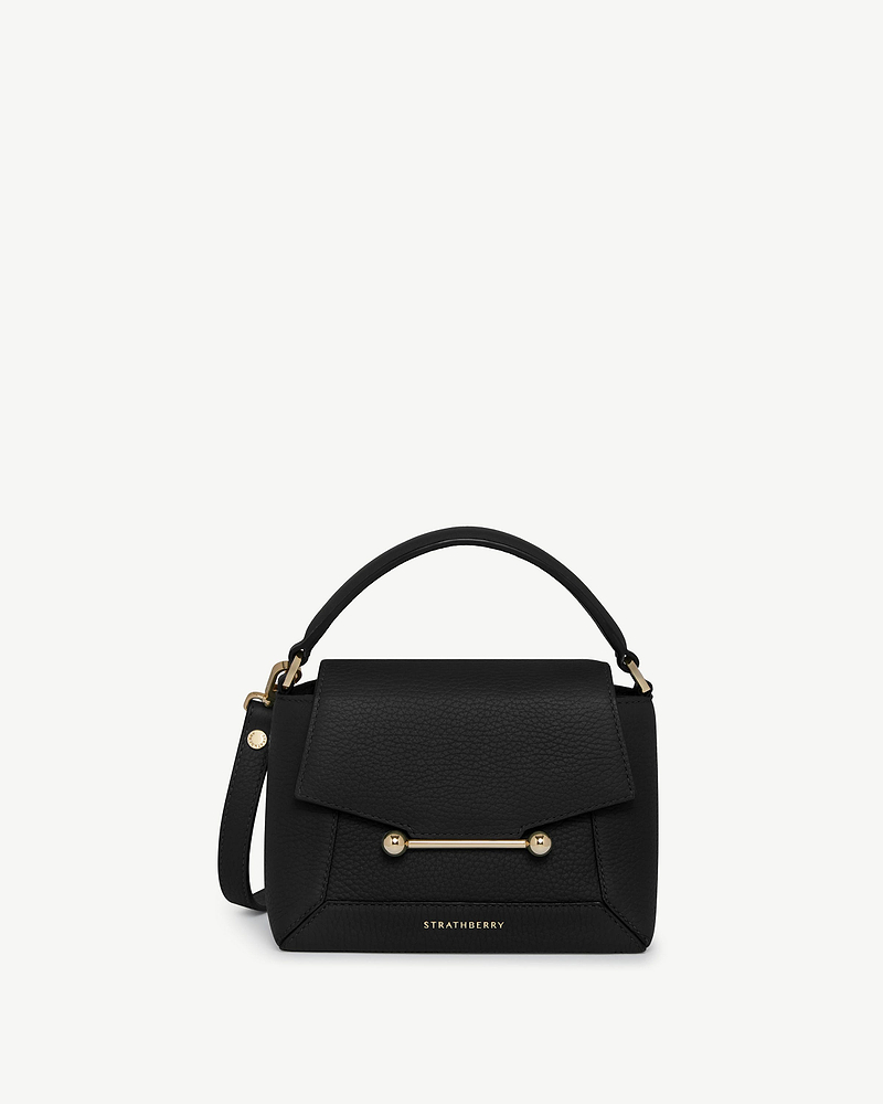 Strathberry Mosaic Nano bag in black with top handle and gold bar detail.