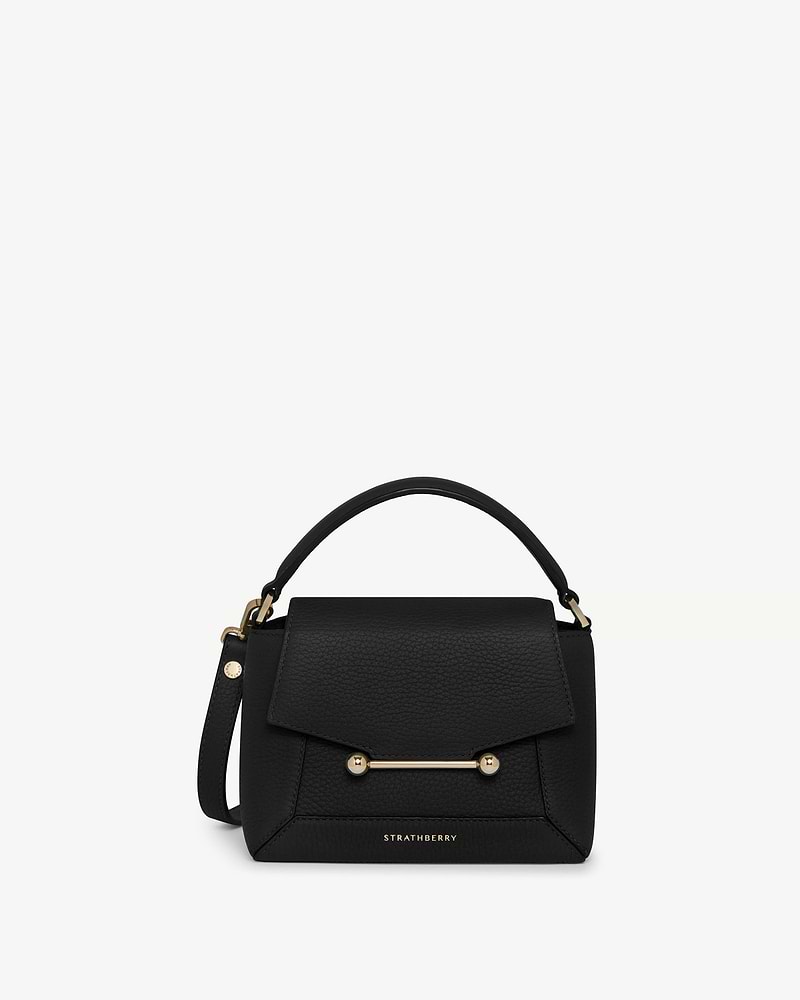 Strathberry Mosaic Nano bag in black with top handle and gold bar detail.