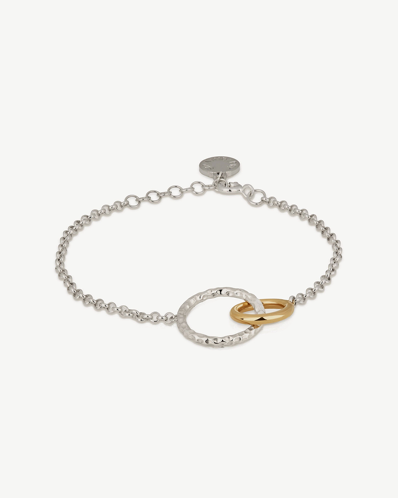 Sterling silver chain bracelet with hammered halo and two 24-carat gold-gilded rings.