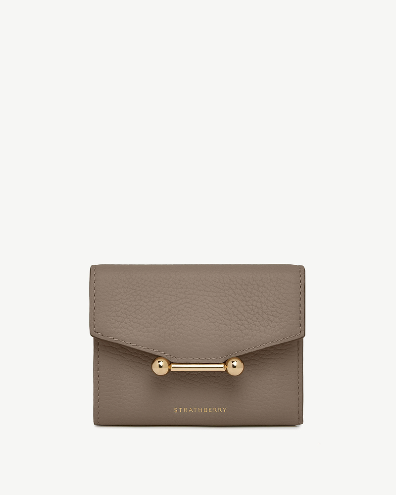 Taupe trifold leather wallet with gold bar closure and Strathberry logo.
