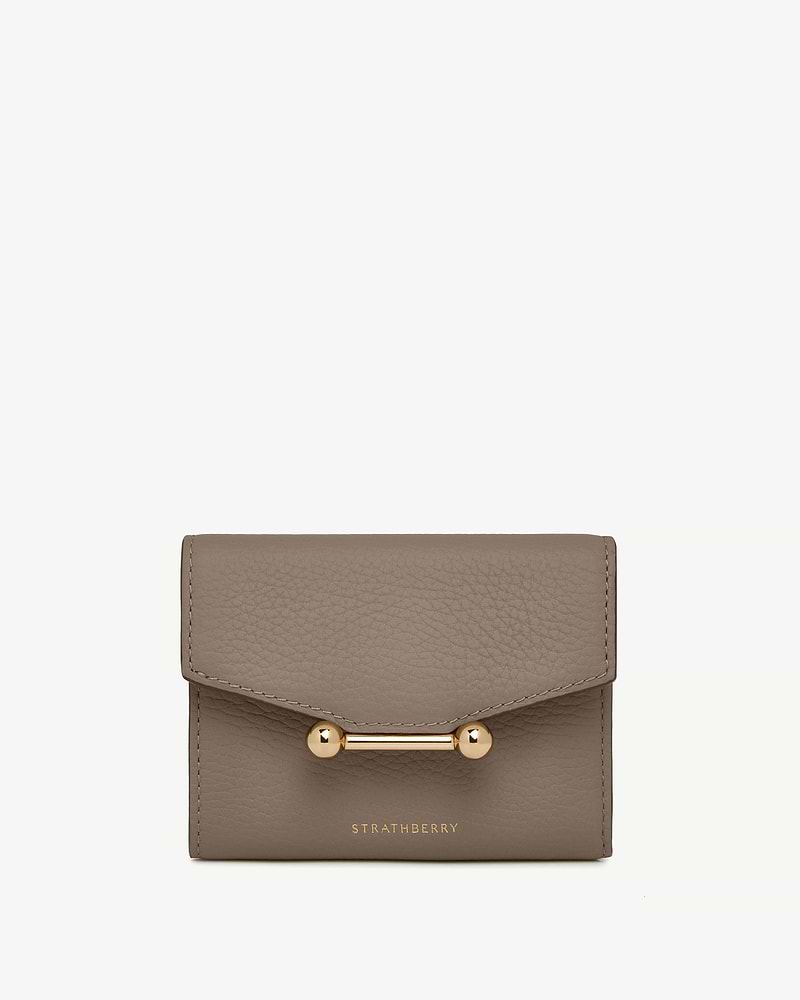 Taupe trifold leather wallet with gold bar closure and Strathberry logo.