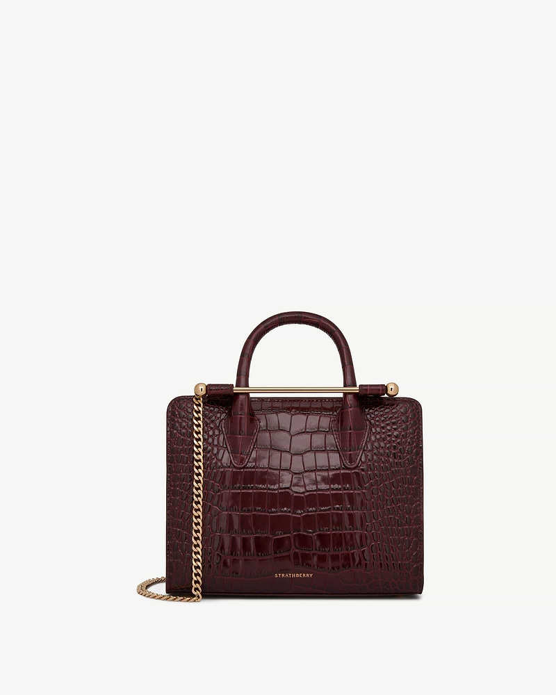Burgundy croc mini tote with gold bar handle and chain strap, Strathberry logo