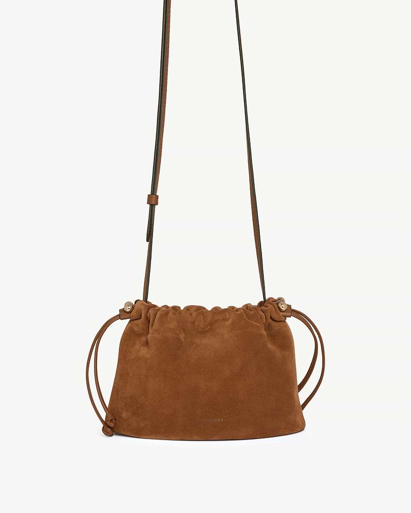 Tan suede drawstring bag with long adjustable shoulder strap and side cords.