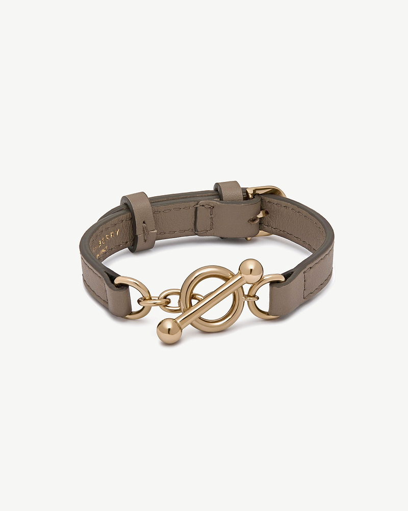 Taupe leather Kite bracelet with gold toggle clasp on white background.