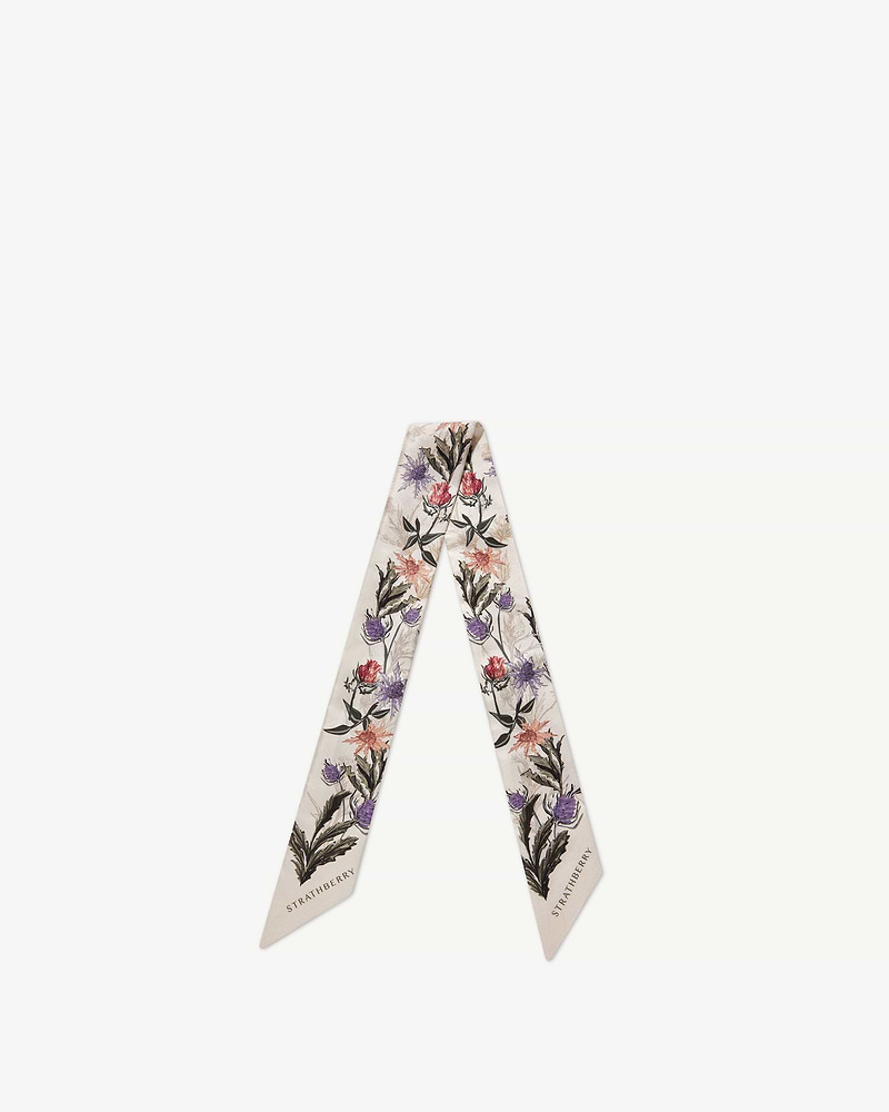 Strathberry vanilla silk skinny scarf with forest green thistle print, laid flat.