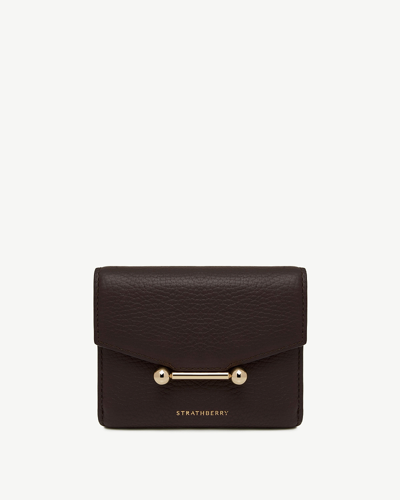 Espresso leather trifold wallet with gold bar hardware and Strathberry wordmark.