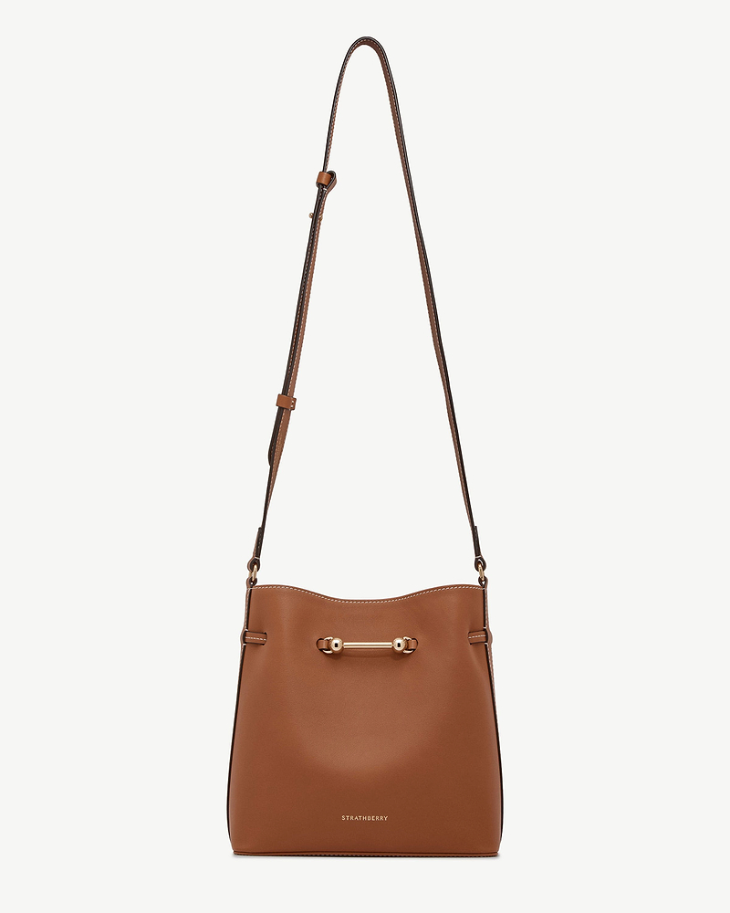 Strathberry chestnut Corda bucket bag with adjustable strap and metal bar.