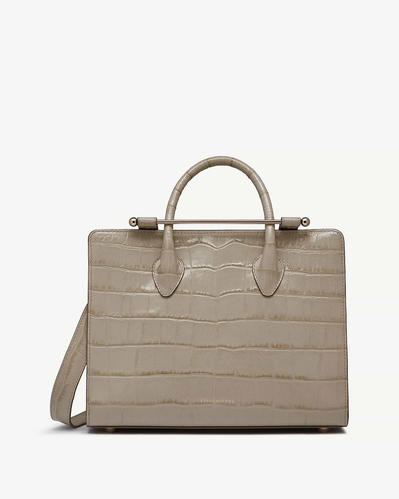 Strathberry midi tote in croc-embossed leather with top handles, shoulder strap, gold bar.