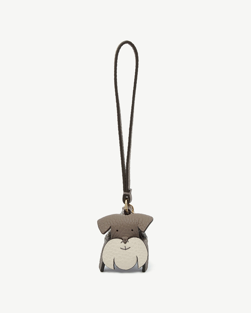Grey leather dog-shaped bag charm with long strap and tartan side panels.