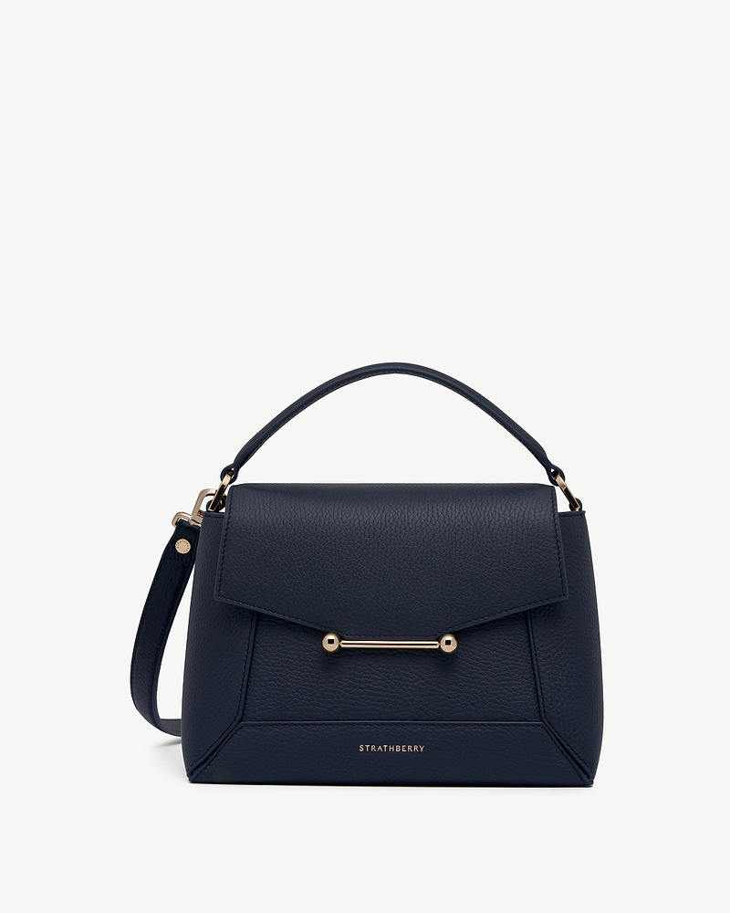 Navy Strathberry mosaic bag with top handle and gold bar detail.